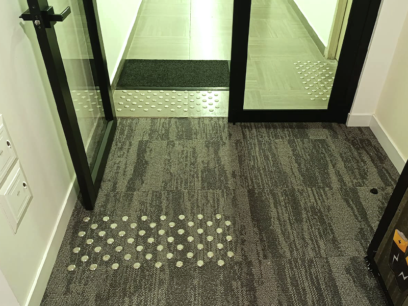 Pisos podotáctiles de guía para personas con discapacidad visual instalados en una acera urbana, mejorando la accesibilidad.
